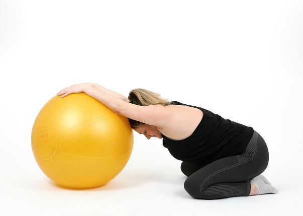 showing back stretch using a gym ball
